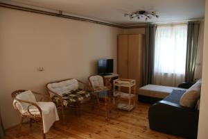 uma sala de estar com um sofá, uma mesa e cadeiras em Guest House Sergey em Kolašin