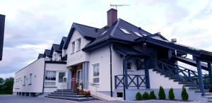 コシチェジナにあるGościniec 16-TKAの黒屋根の白い建物