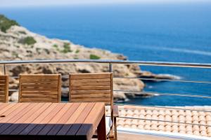 drewniany stół i krzesła na balkonie z widokiem na ocean w obiekcie Moonkey - Casa El Cabo w mieście Balcon del Mar