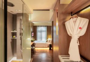 a dressing room with a robe hanging on a wall at AMOY by Far East Hospitality in Singapore