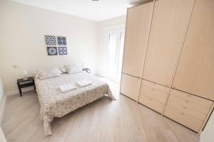 a white bedroom with a bed and a large cabinet at Espacios Blanco Plaza Mayor in Valladolid