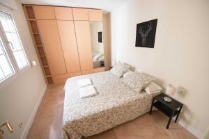 Dormitorio pequeño con cama y armario en Espacios Blanco Plaza Mayor, en Valladolid