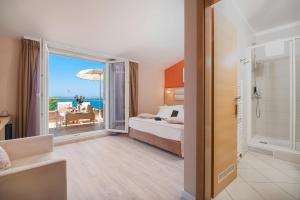 a hotel room with a bed and a view of the ocean at Hotel Maritimo in Makarska