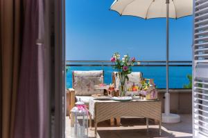 a balcony with a table and chairs and an umbrella at Hotel Maritimo in Makarska