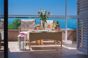 una mesa con un jarrón de flores en el balcón en Hotel Maritimo en Makarska