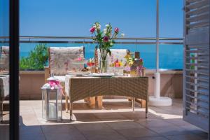 a table that has a vase with flowers on it at Hotel Maritimo in Makarska