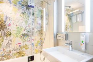 a bathroom with a sink and a shower curtain at ibis Styles Paris Boulogne Marcel Sembat in Boulogne-Billancourt +30 photos