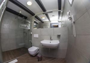 ein Bad mit einem Waschbecken, einem WC und einem Telefon in der Unterkunft Chalet Greenwood in Beloe Ozero