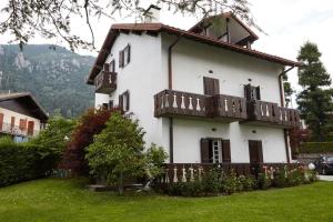 a white house with a balcony on the side of it at Lo Chalet in Castione della Presolana