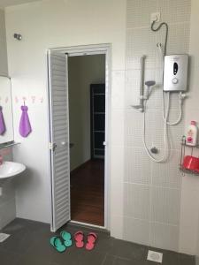 a bathroom with a shower and two pairs of flip flops at Ipoh Water Front City Homestay in Ipoh