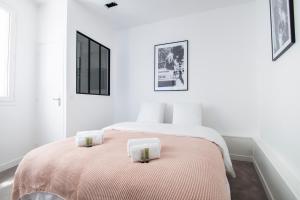 een witte slaapkamer met 2 bedden en handdoeken bij Dreamyflat - Eiffel tower in Parijs