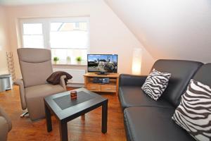 a living room with a couch and a chair and a tv at Haus Köhler in Büsum