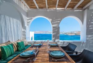 una sala da pranzo con tavolo e vista sull'oceano di Dreambox Mini Villas a Ornos