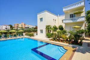 a large swimming pool in front of a villa at Poseidon Apartments in Kato Daratso