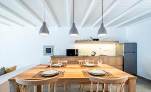 una sala da pranzo con tavolo e sedie in legno di Dreambox Mini Villas a Ornos
