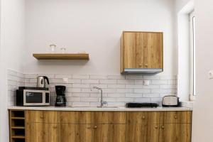 una cucina con armadi in legno e forno a microonde di Terpsis Lodge a Heraklion