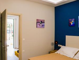 sypialnia z łóżkiem i niebieską ścianą w obiekcie Terpsis Lodge w Heraklionie