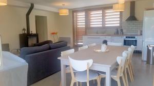 a kitchen and living room with a white table and chairs at Gites Domaine de Ceyrac in Conqueyrac
