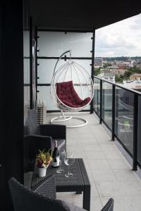 een balkon met een schommel en een tafel met wijnglazen bij VIP Apartment AVALON in Lviv