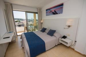 a hotel room with a bed and a balcony at Hotel Bella Mar in Cala Ratjada