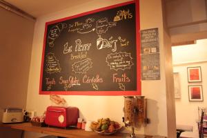 a blackboard on the wall in a kitchen with a bowl of fruit at Hôtel Des Arts, Artisanal et Indépendant in Montpellier