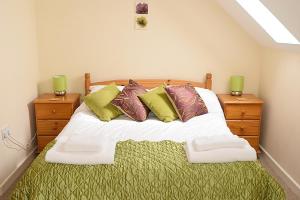 sypialnia z łóżkiem z poduszkami i 2 szafkami nocnymi w obiekcie Sand Dunes Penthouse Apartment w mieście Perranporth