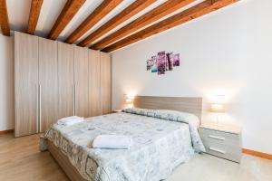 a bedroom with a large bed and a wooden ceiling at Colombina's roof in Venice