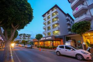a white car parked in front of a hotel at Alanya Beach Hotel in Alanya