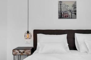 a bedroom with a bed with white sheets and a nightstand at Apartment Teraca in Makarska