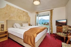 sypialnia z dużym łóżkiem i oknem w obiekcie Hotel-Pension Melcher w mieście Drobollach am Faakersee