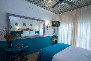 雅典Rastoni Athens Suites near Acropolis at Tsatsou street的一间带床和镜子的蓝色卧室