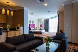 a living room with a couch and a table at Kingsgate Hotel Doha by Millennium Hotels in Doha