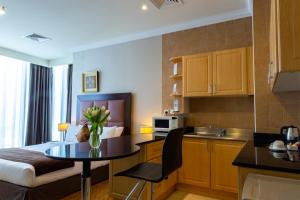 a small kitchen with a table in a room at Kingsgate Hotel Doha by Millennium Hotels in Doha