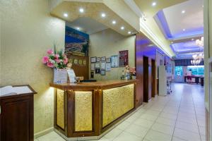a hotel lobby with a reception counter and flowers at Alanya Beach Hotel in Alanya +25 photos