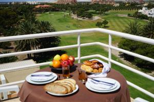 a table with bread and fruit on a balcony at APARTAMENTOS MAR Y GOLF in Roquetas de Mar