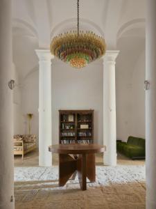 a living room with a table and a chandelier at Villa Lena in Palaia