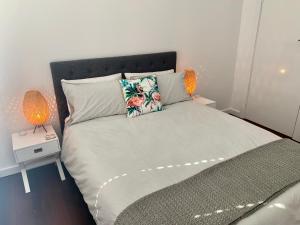 a bedroom with a bed with two lamps on it at Yaringa Cottage by the sea in Busselton