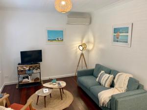 a living room with a couch and a tv at Yaringa Cottage by the sea in Busselton