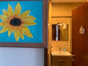 La salle de bains est ornée d'une peinture murale représentant un tournesol. dans l'établissement Sun & Sea 509, à Sesimbra 12 autres photos