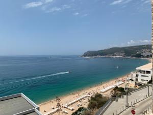 une vue d'une plage avec des gens et l'océan dans l'établissement Sun & Sea 509, à Sesimbra