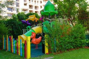 a playground with a colorful play equipment in a yard at Sweet Homes Apartments in Sunny Beach