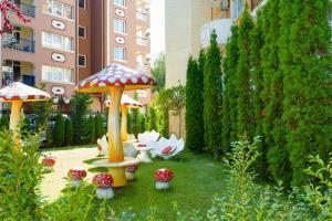 a garden with a group of mushrooms in the grass at Sweet Homes Apartments in Sunny Beach