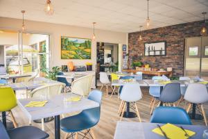 a restaurant with tables and chairs and a brick wall at Hôtel Le Plaisance in Mimizan-Plage