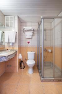 a bathroom with a toilet and a glass shower at Alanya Beach Hotel in Alanya