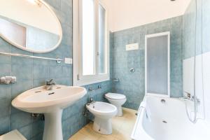 een badkamer met een wastafel, een toilet en een spiegel bij La Bauta in Venetië