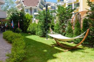 a hammock sitting on the grass near a building at Sweet Homes Apartments in Sunny Beach