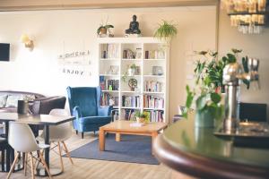 a living room with a book shelf filled with books at Hôtel Le Plaisance in Mimizan-Plage