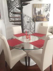 einen Esstisch mit weißen Stühlen und einem Glastisch in der Unterkunft Gioiello di Venezia, Suite Calle del Forno in Venedig