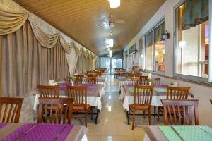 jadalnia ze stołami, krzesłami i purpurowymi stołami w obiekcie Alanya Beach Hotel w mieście Alanya