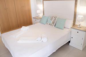 a large white bed with two towels on it at Domatsea Salou Paradise in Salou